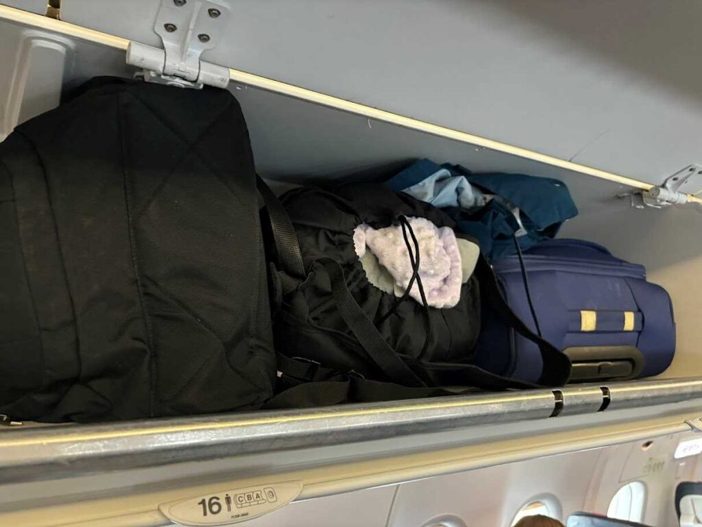 Cibex Libelle ultracompact stroller with storage bag in the overhead compartment of our plane to Brussels with Brussels Airlines - Canary Family on Board